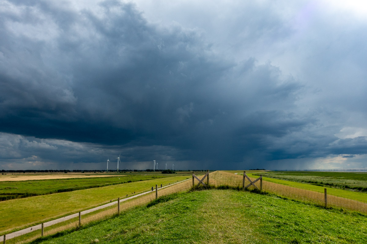 Auf der Deichkrone beim Pilsumer Leuchtturm mit Blick in Richtung Westen nach Groningen auf ein Unwetter 