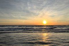 Sonnenaufgang! Die Sonne steht gerade oberhalb der Wasseroberfläche und über den Wellen der Ostsee